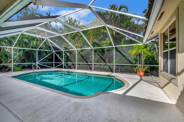 view of swimming pool with glass enclosure and a patio