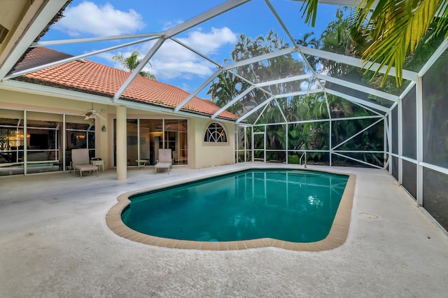 view of swimming pool featuring ceiling fan, a patio area, and a lanai