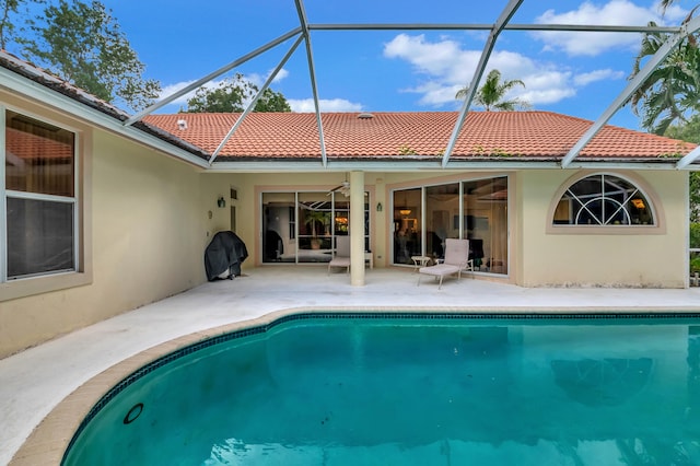 view of swimming pool with a patio and glass enclosure