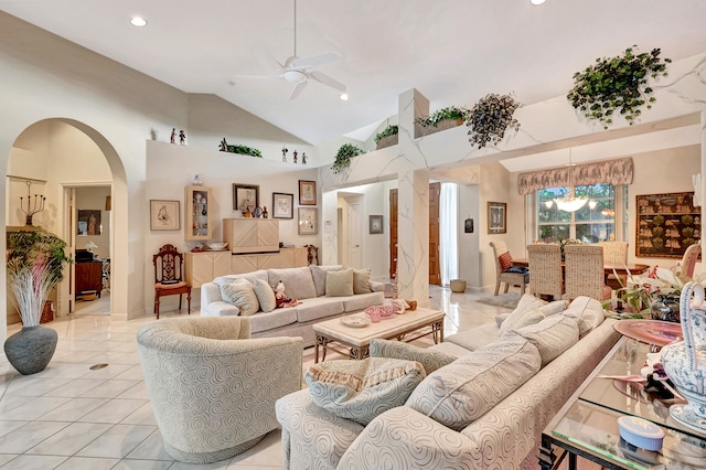 living room featuring high vaulted ceiling, light tile patterned flooring, and ceiling fan with notable chandelier