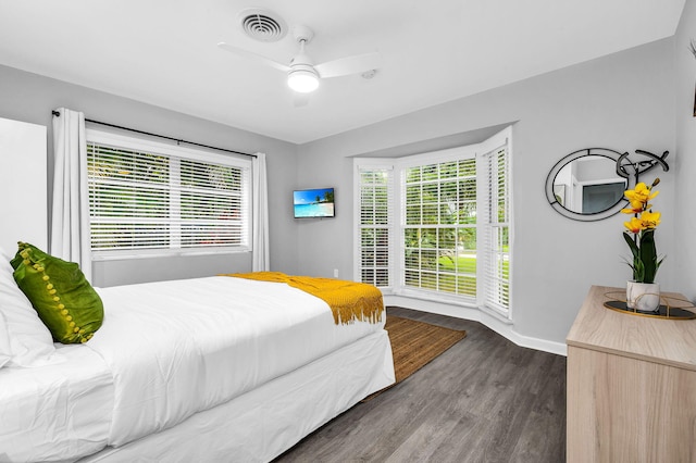 bedroom with dark hardwood / wood-style flooring, multiple windows, and ceiling fan