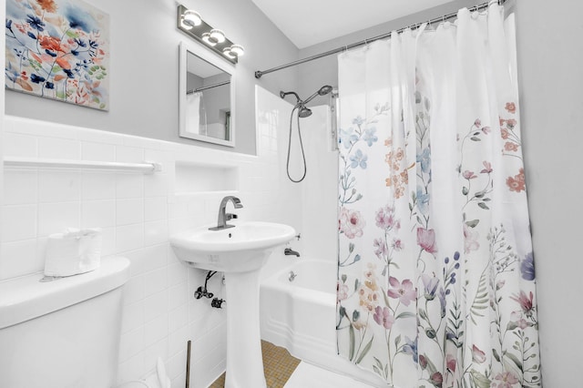 bathroom with shower / bathtub combination with curtain, tile walls, and toilet