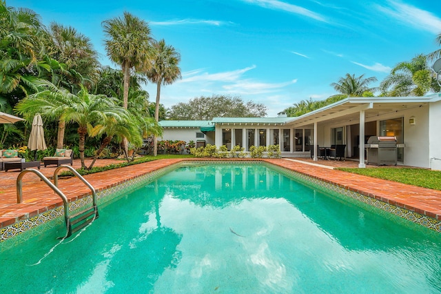 view of swimming pool with area for grilling and a patio