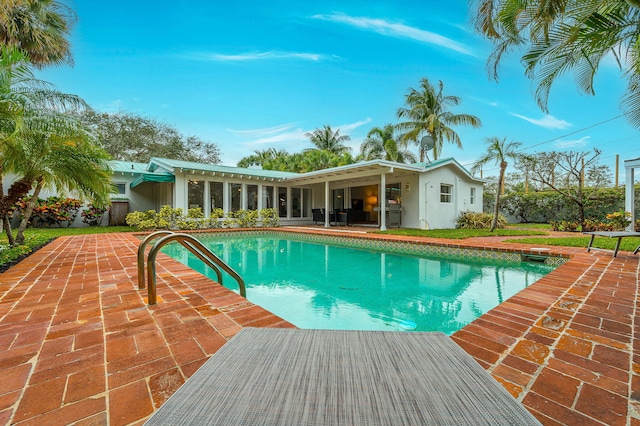 view of swimming pool with a lawn and a patio