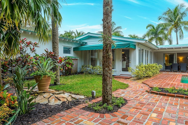 rear view of property with a patio area and a lawn