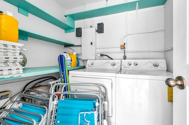 laundry room featuring electric panel and separate washer and dryer