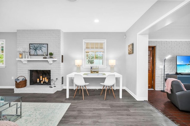 dining room featuring a fireplace and dark wood-type flooring