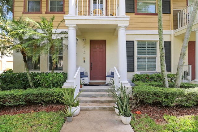 view of exterior entry featuring a balcony