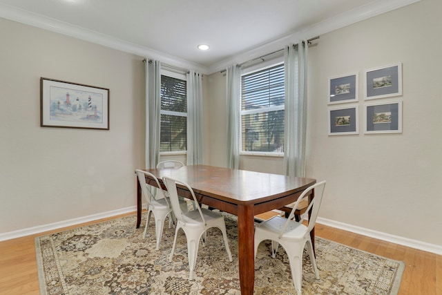 dining area with crown molding and light hardwood / wood-style flooring