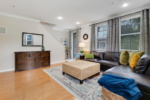 living room with light hardwood / wood-style floors and crown molding