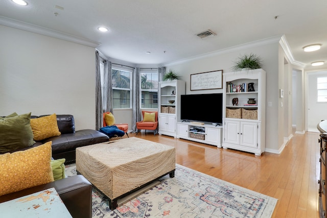 living room featuring a healthy amount of sunlight, light wood-type flooring, and crown molding