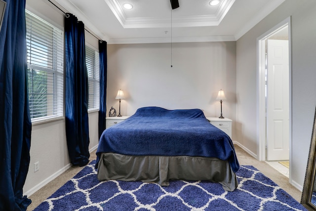 carpeted bedroom with ornamental molding, ceiling fan, and a raised ceiling