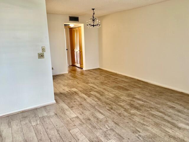 interior space featuring light hardwood / wood-style flooring, a chandelier, and a textured ceiling