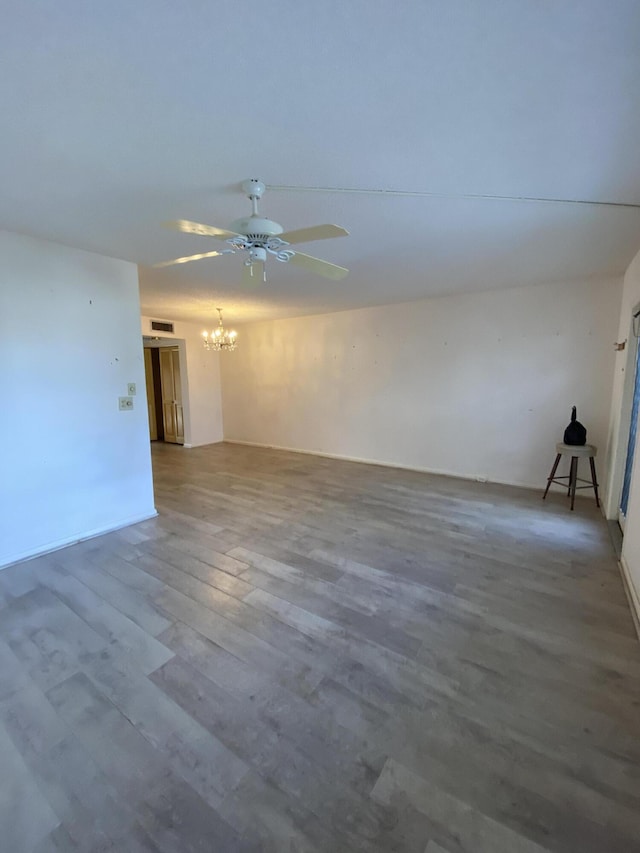 unfurnished room featuring hardwood / wood-style floors and ceiling fan with notable chandelier