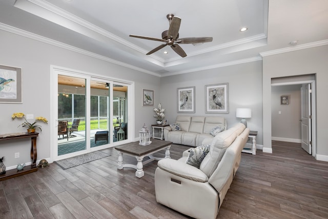 living room with hardwood / wood-style floors, ceiling fan, ornamental molding, and a tray ceiling