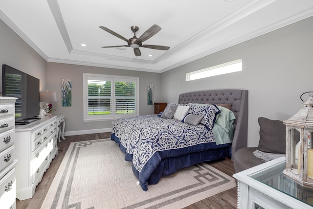 bedroom with a tray ceiling, ceiling fan, ornamental molding, and dark hardwood / wood-style floors