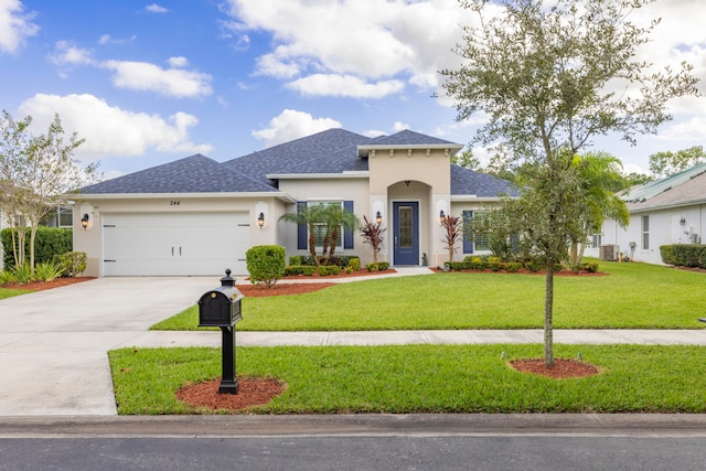 view of front of house featuring central air condition unit, a front lawn, and a garage