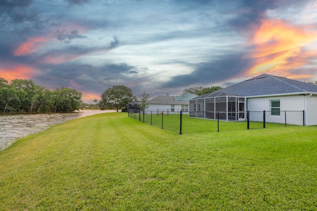 yard at dusk featuring a lanai