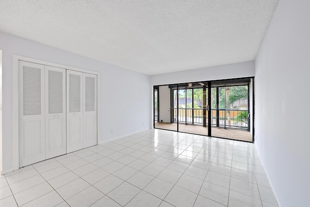 tiled empty room with a textured ceiling