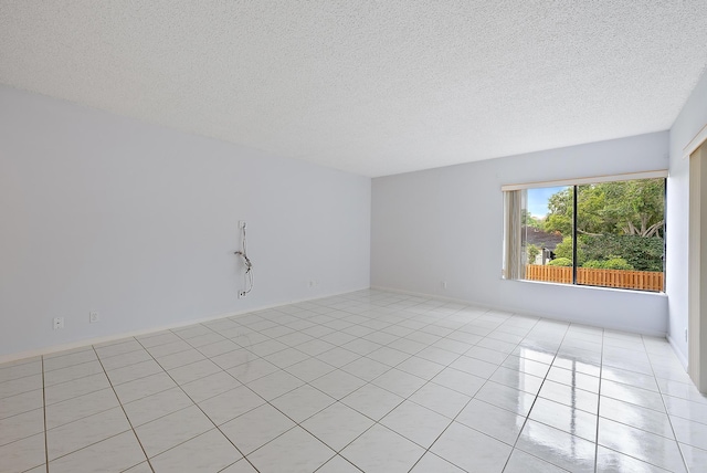 unfurnished room featuring a textured ceiling and light tile patterned flooring