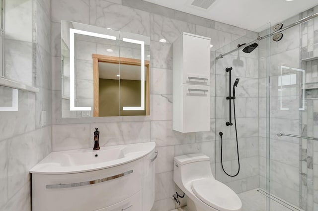 bathroom featuring vanity, toilet, an enclosed shower, and tile walls