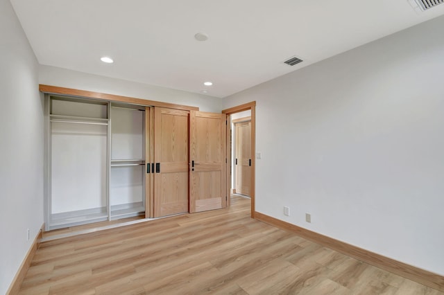 unfurnished bedroom featuring light wood-type flooring and a closet