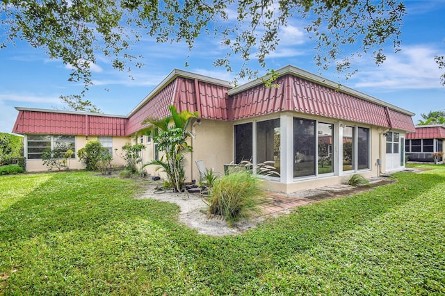 back of house with a sunroom and a yard