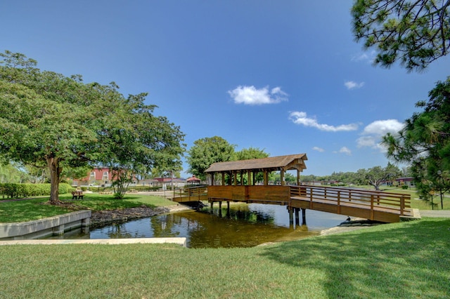 view of dock featuring a lawn and a water view