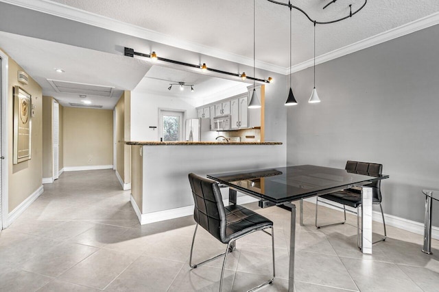 dining area featuring light tile patterned flooring, crown molding, and a textured ceiling