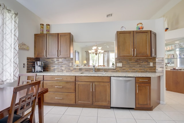 kitchen featuring dishwasher, decorative backsplash, sink, and light stone counters