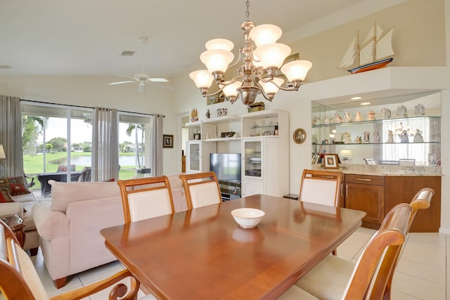 dining space with ceiling fan with notable chandelier, light tile patterned floors, and lofted ceiling