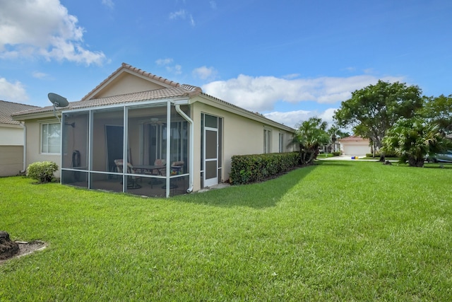 back of house with a sunroom and a yard