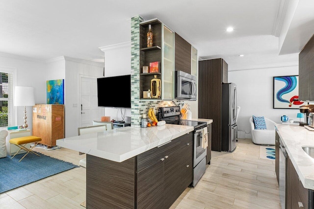 kitchen featuring dark brown cabinetry, light wood-type flooring, a kitchen bar, appliances with stainless steel finishes, and ornamental molding