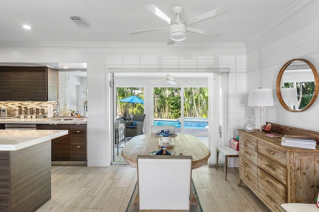 interior space featuring access to outside, crown molding, and light hardwood / wood-style floors