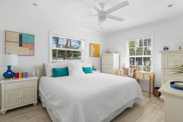 bedroom featuring ceiling fan, ornamental molding, and light hardwood / wood-style flooring