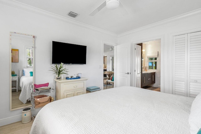 bedroom featuring ceiling fan, a closet, crown molding, and light wood-type flooring