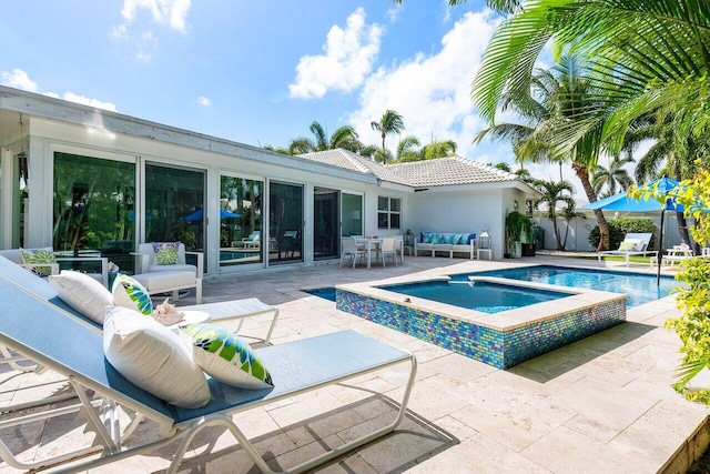 view of pool with an in ground hot tub, a patio, and an outdoor hangout area