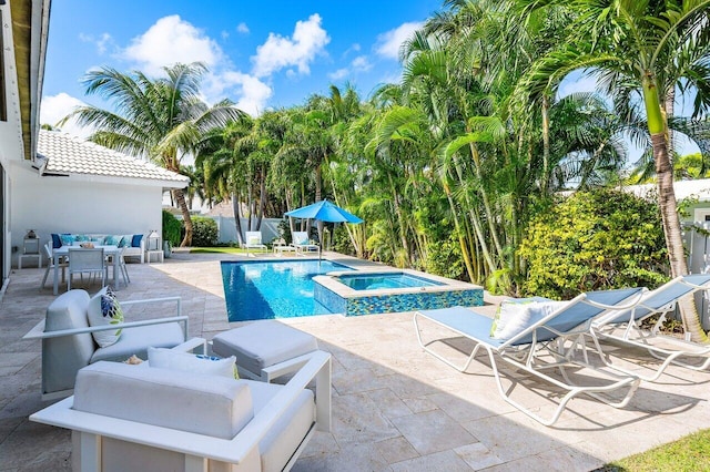 view of pool featuring a patio area and an in ground hot tub