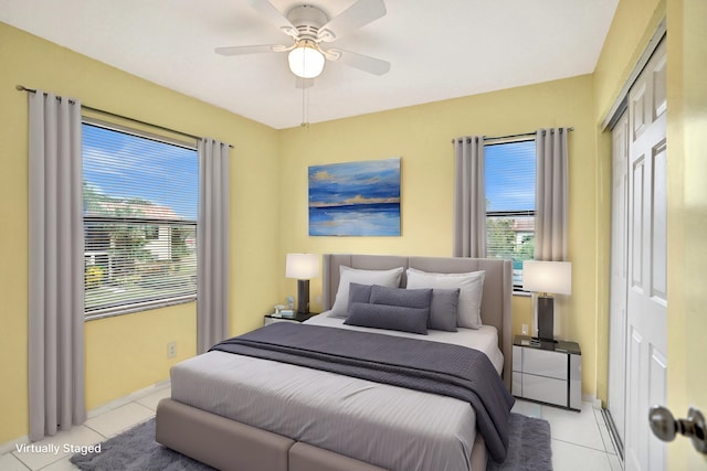 bedroom with light tile patterned floors, a closet, and ceiling fan