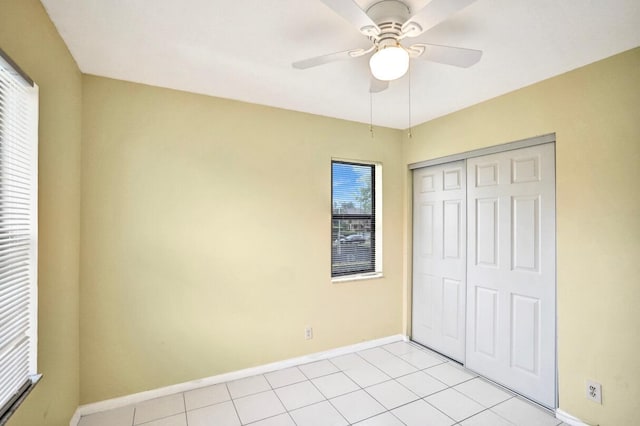 unfurnished bedroom with ceiling fan, light tile patterned floors, and a closet