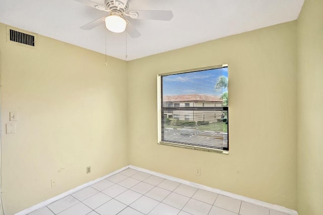 tiled spare room with ceiling fan