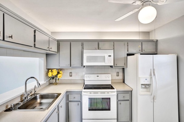 kitchen with gray cabinetry, decorative backsplash, white appliances, and sink