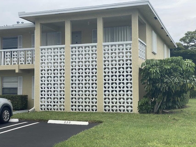 view of property exterior featuring a balcony and a yard