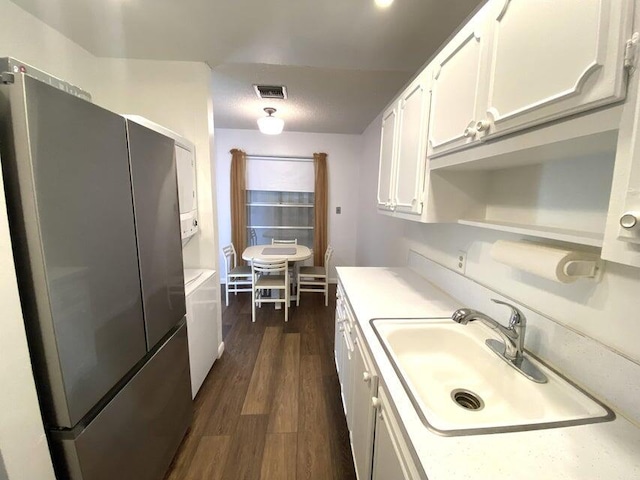 kitchen with white cabinets, stainless steel fridge, sink, and dark wood-type flooring