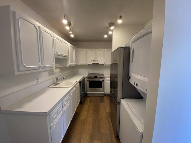 kitchen with sink, white cabinets, stainless steel appliances, and stacked washer / drying machine