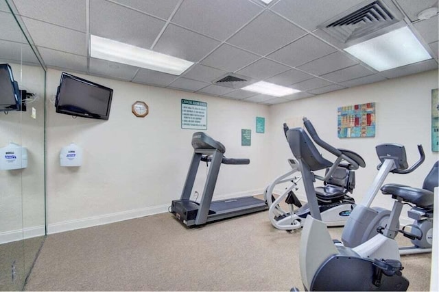 exercise area featuring a paneled ceiling and carpet