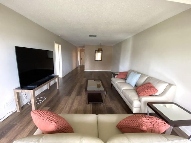 living room with dark hardwood / wood-style flooring and a textured ceiling