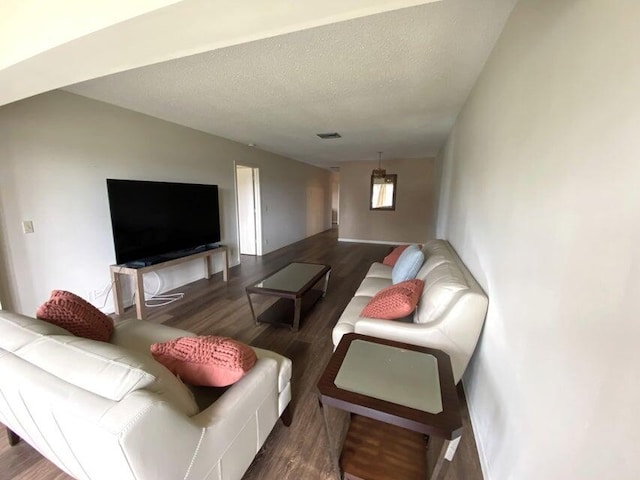 living room featuring a textured ceiling and dark hardwood / wood-style flooring