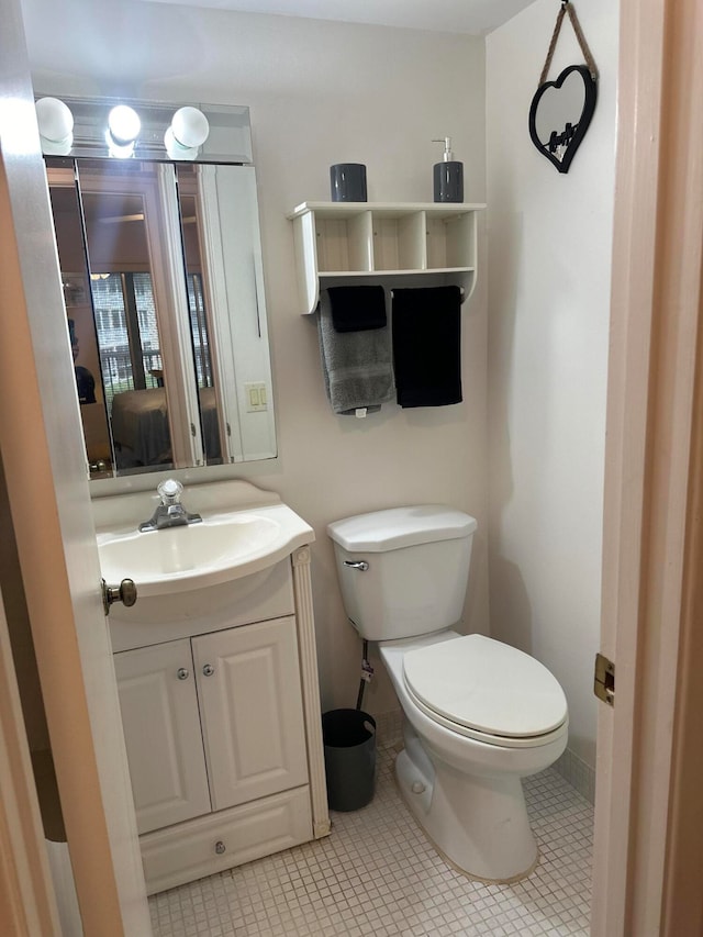 bathroom featuring tile patterned floors, vanity, and toilet