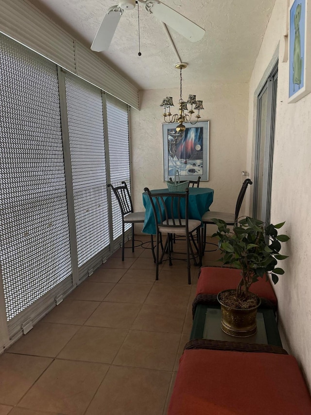 sunroom with ceiling fan with notable chandelier